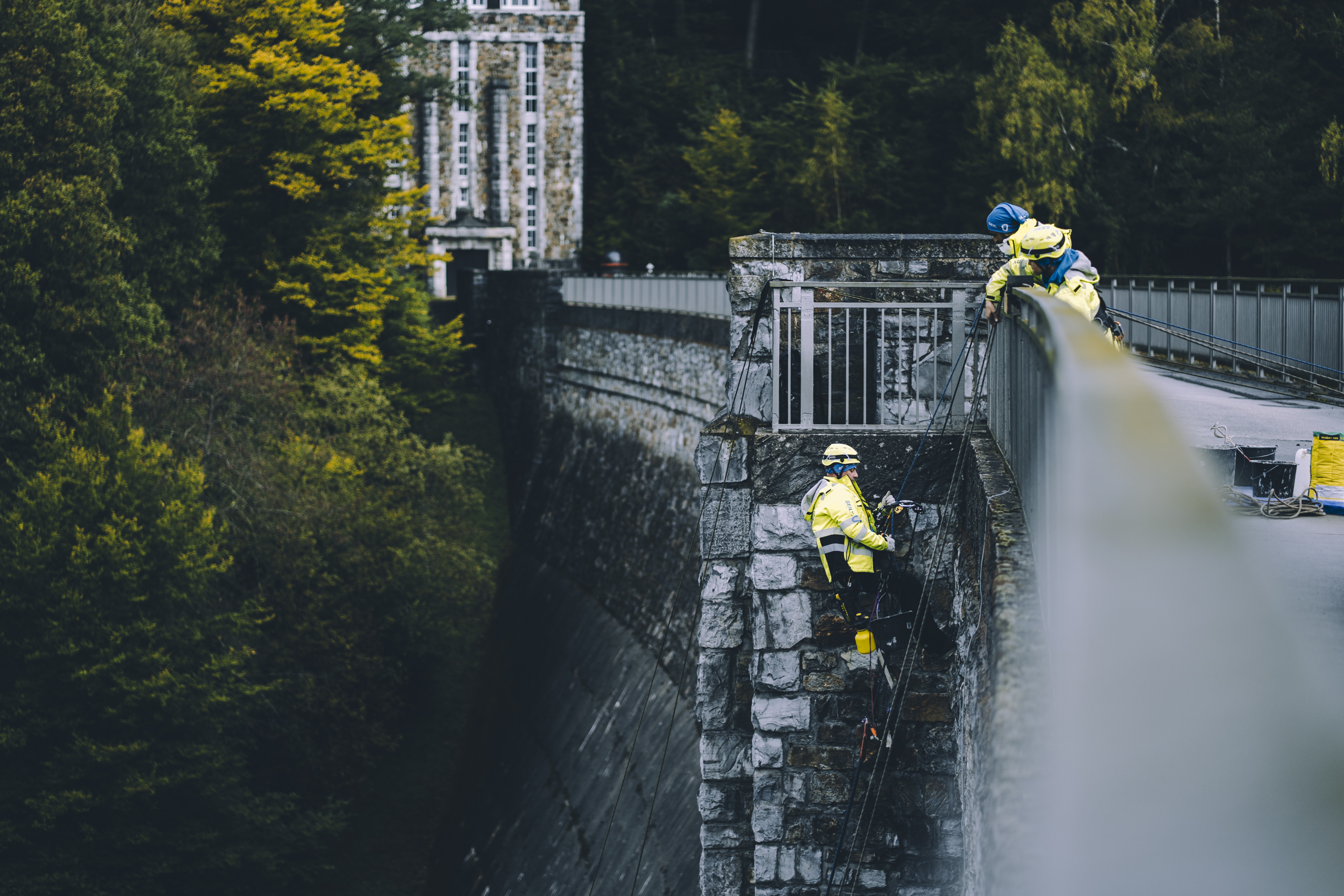 industrie-kletterer-abseilen-stau-eifel-betonreparaturen Industrie Kletterer seilt sich an einem Staudamm in der Eifel ab, um Betonreparaturen durchzuführen.